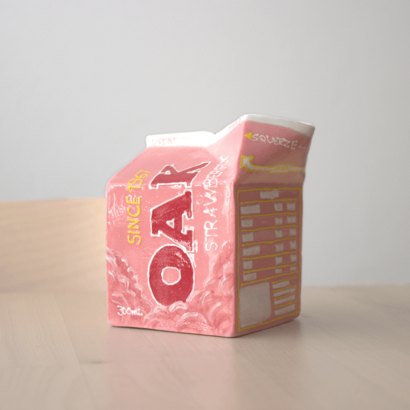 Pink carton with 'OAK' branding on a wood table
